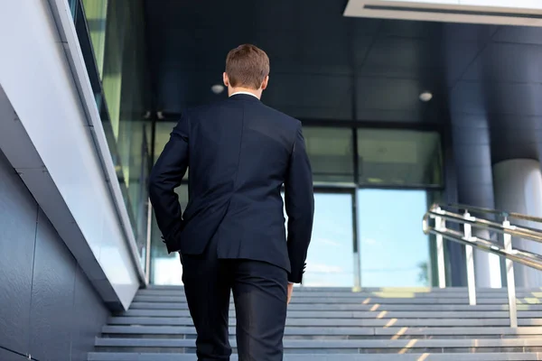 スタイリッシュな成功したビジネスマンは オフィスビルの階段を上ります — ストック写真