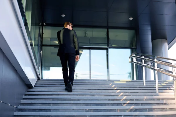 スタイリッシュな成功したビジネスマンは オフィスビルの階段を上ります — ストック写真