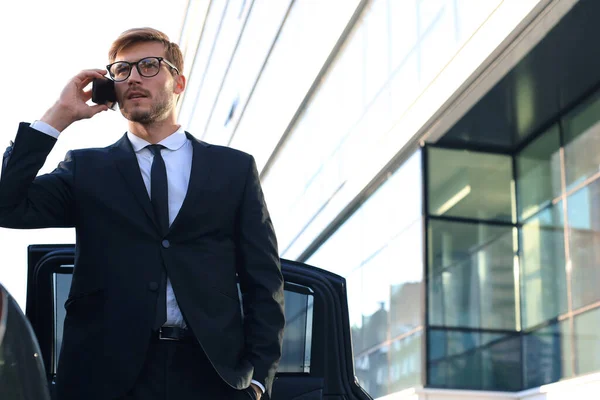ハンサムな真面目な若いビジネスマンは 彼の快適な新しい車の近くに立って オフィスに行く — ストック写真