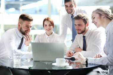 Bir grup iş ortağı ofiste fikir ve planlama işini tartışıyor.