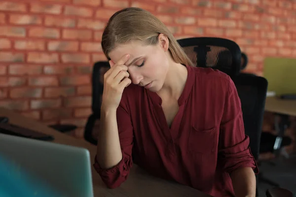 働く場所に座っている間に疲れ果てているビジネス女性 — ストック写真