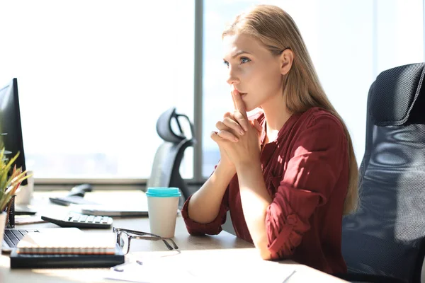 Frustrated business woman looking exhausted while sitting at her working place.