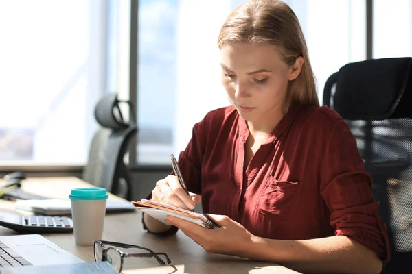 Piękna Bizneswoman Zapisuje Coś Siedząc Biurze — Zdjęcie stockowe