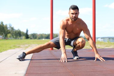 Sportif adam dışarıda bacaklara egzersiz yaptırıyor..