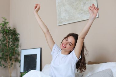 Kadın uyandıktan sonra yatakta geriniyor.