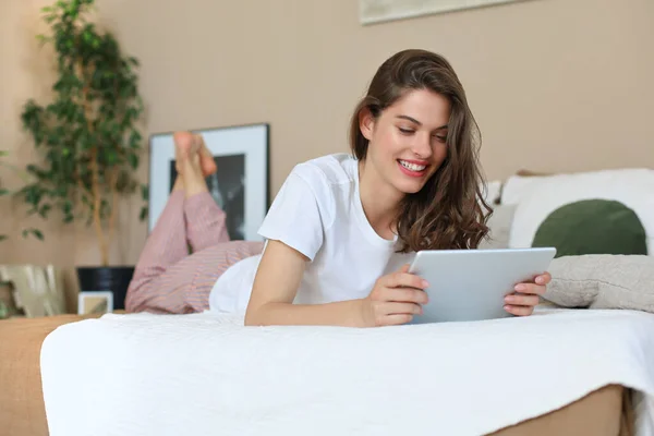 Mujer Sonriente Está Acostada Cama Utilizar Tableta Digital —  Fotos de Stock