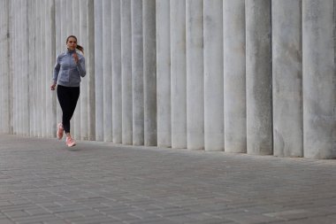 Çekici, genç, sportif bir kadın. Açık havada koşuyor..