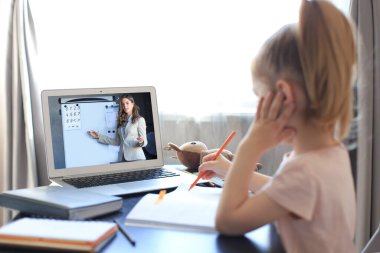 Mesafe öğrenme. Çevrimiçi e-öğrenme sisteminde çalışırken dizüstü bilgisayar kullanan neşeli küçük kız