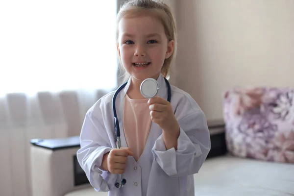 Sorridente Bambina Uniforme Medica Che Gioca Con Stetoscopio Casa — Foto Stock