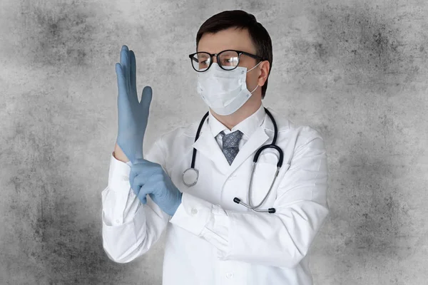 医护人员对头皮病毒的防护装备 带听诊器戴医用手套的男医生 在灰色背景下隔离 — 图库照片