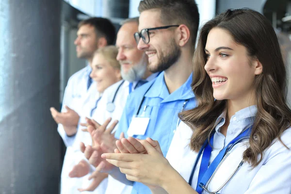 Group of doctors applauds, standing in the hospital