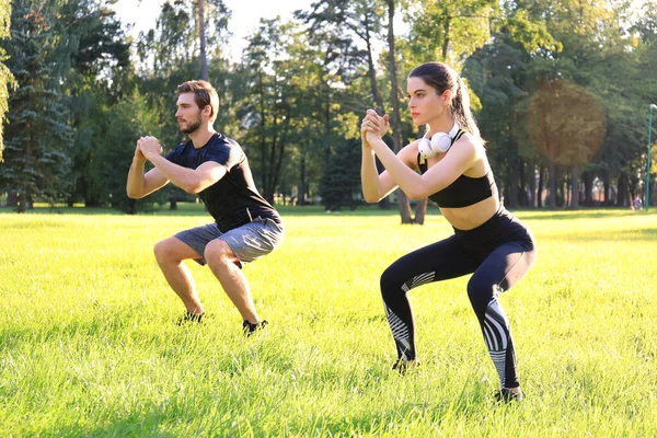 Jovem Desportivo Homem Mulher Fazendo Treino Agachamento Juntos Parque Verde — Fotografia de Stock