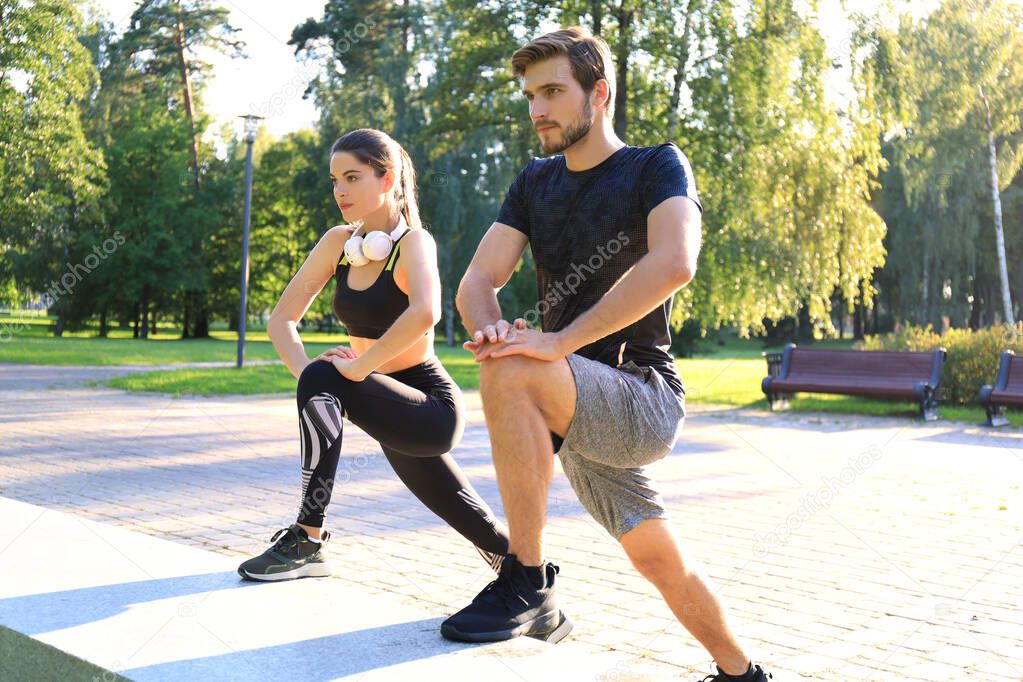 Happy young couple exercising together in a park