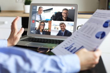 İş kadını video konferansında iş arkadaşlarıyla konuşuyor. İş ekibi laptopla evden çalışıyor..