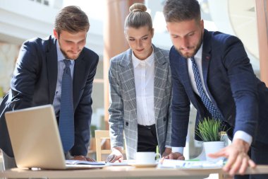 Bir grup iş ortağı ofiste fikir ve planlama işini tartışıyor.