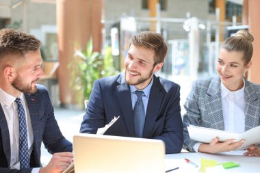 Bir grup iş ortağı ofiste fikir ve planlama işini tartışıyor.