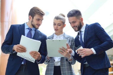 Ofis toplantısında iş görüşmesi ne zaman ayakta duran üç genç işadamı