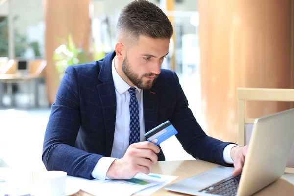 Hombre Sonriente Sentado Oficina Paga Con Tarjeta Crédito Con Computadora — Foto de Stock