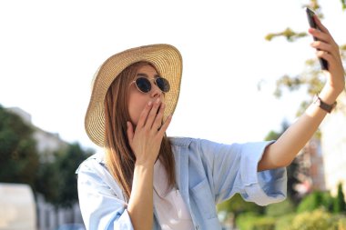 Güzel sarışın kız dışarıda beklerken cep telefonu kullanıyor.