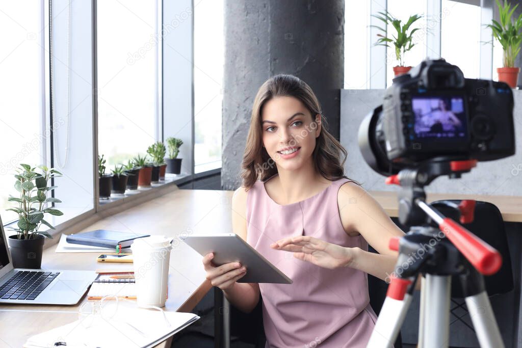 Beautiful young woman talking and smiling while making new video for her blog