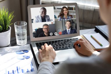 İş kadını video konferansında iş arkadaşlarıyla konuşuyor. Laptop kullanarak evden çalışan çok ırklı iş adamları.