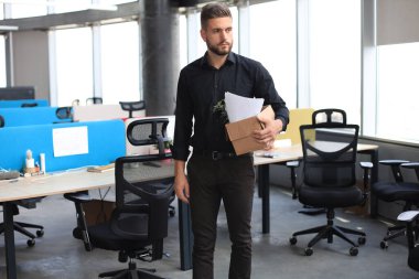 Üzgün işçi ofis malzemelerini yanında götürüyor..