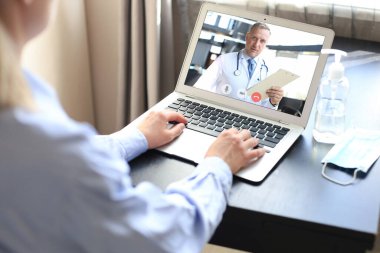 Kendini tecrit ve karantina sırasında doktoruyla görüntülü konuşma yapan genç bir kadın. Online danışmanlık. Dijital tablette pratisyen hekimle görüntülü görüşme yapan hasta. Coronavirüs
