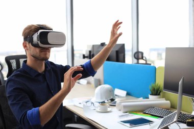 Yeni bir binada VR kulaklık takan bir mühendisin fotoğrafı. Dünyaya bakış açını ve deneyimini değiştir.