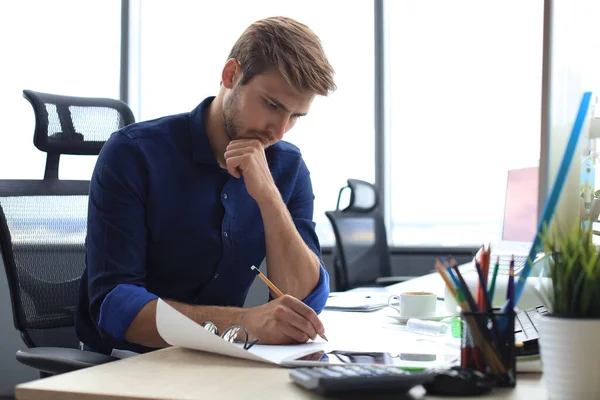 Yorgun Genç Adam Ofiste Otururken Kağıtlarla Uğraşıyor — Stok fotoğraf