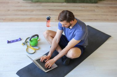 Karantina sırasında evde spor yapan yakışıklı bir adam. Sağlıklı yaşam kavramı