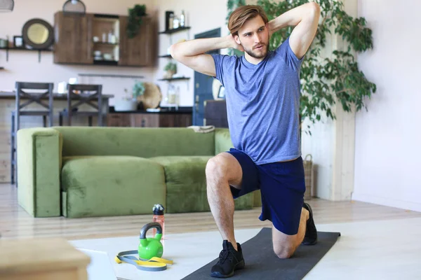 在检疫期间 英俊的男人在家里做运动锻炼 健康生活的概念 — 图库照片