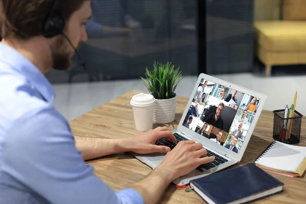 Empresário em fones de ouvido falar falar sobre videochamada com colegas em briefing on-line durante o auto-isolamento e quarentena. Conferência do grupo Webcam com colegas de trabalho no laptop em casa . — Fotografia de Stock