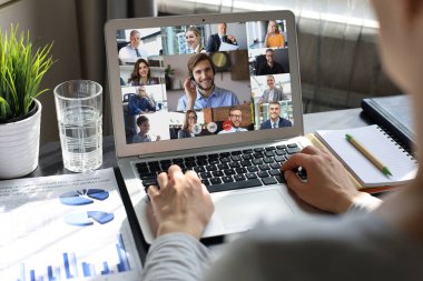 İş kadını video konferansında iş arkadaşlarıyla konuşuyor. İş ekibi laptopla evden çalışıyor..