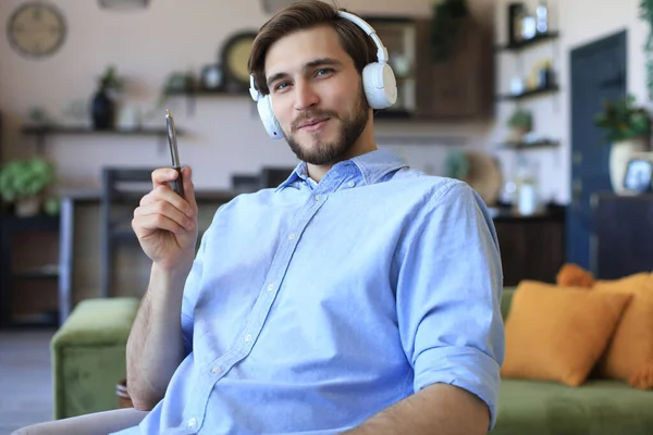 Happy young man in earphones working from home during self isolation