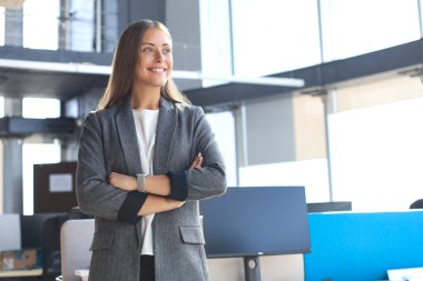 Ofiste dururken gülümseyen çekici bir iş kadını.