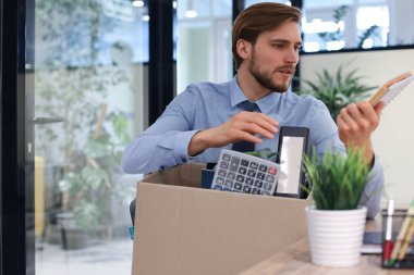 Üzgün işçi ofis malzemelerini yanında götürüyor.