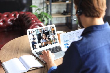 İş adamı video konuşmasında iş arkadaşlarıyla kişisel izolasyon ve karantina sırasında online brifing hakkında konuştu. Ofisteki iş arkadaşlarıyla webcam grup konferansı.