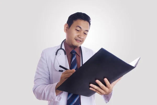 Médico masculino escribiendo el expediente de la medicación del paciente — Foto de Stock