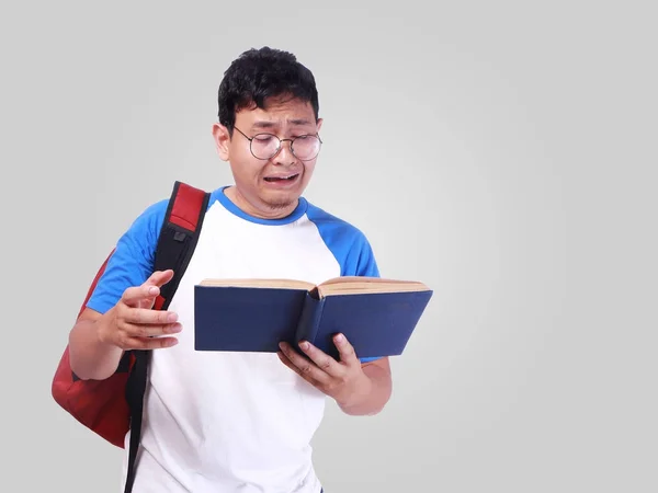 Молодой студент беспокоится, когда читает отчет экзамена — стоковое фото