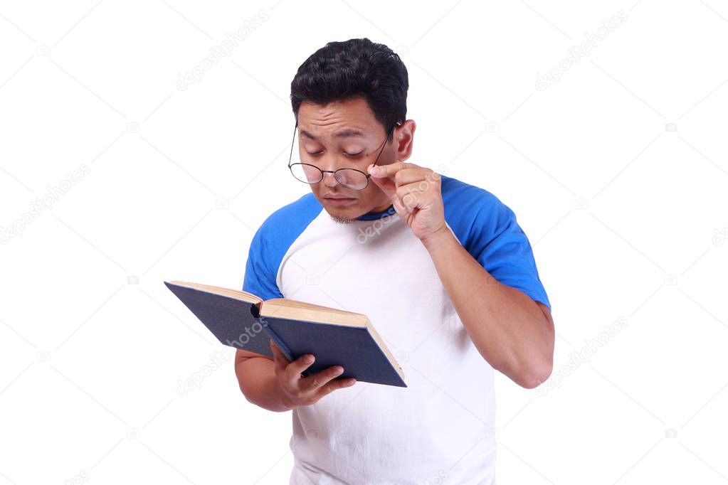 Young Man With Glasses Having Bad Vision When reading Book