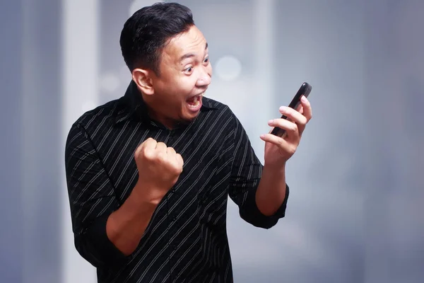 若い男テキスト メッセージ読む彼の携帯電話上でチャットを驚かせた幸せ — ストック写真