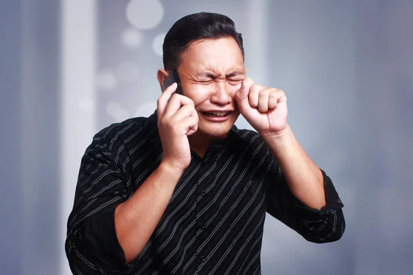 Junger Mann bekommt schlechte Nachrichten am Telefon, schockiert und weint — Stockfoto