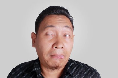 Asya adam komik sarhoş yüz ifadesi gösterir