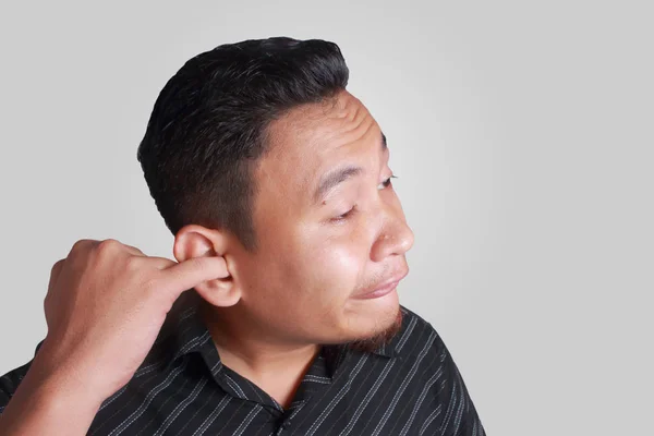 Jeune asiatique homme cueillette son oreille — Photo