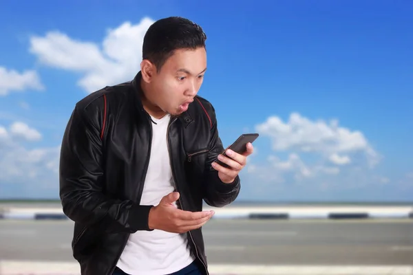 Zaskoczony, czytanie SMS-ów młody człowiek rozmowy jego telefon Gestur — Zdjęcie stockowe