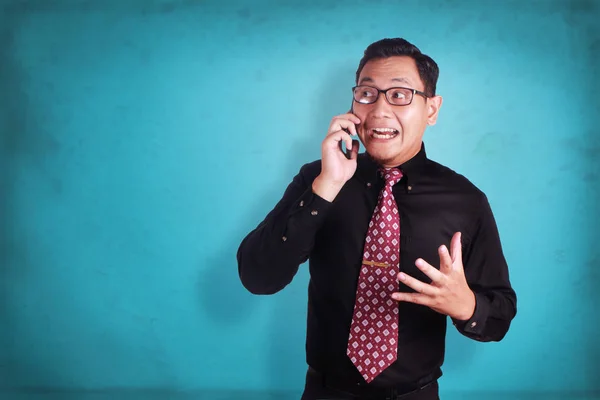 Привлекательный молодой бизнесмен разговаривает по телефону, шокирован криком — стоковое фото