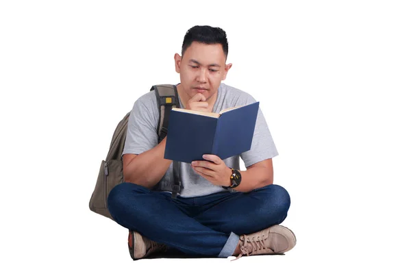 Молодой студент читает книгу, серьезный жест — стоковое фото