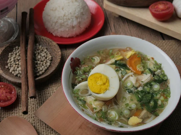 Индонезийская курица сото или сото айям, подается с белым рисом — стоковое фото
