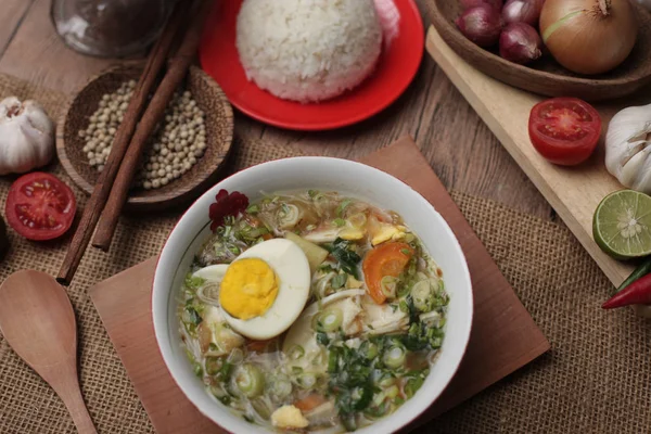 Индонезийская курица сото или сото айям, подается с белым рисом — стоковое фото