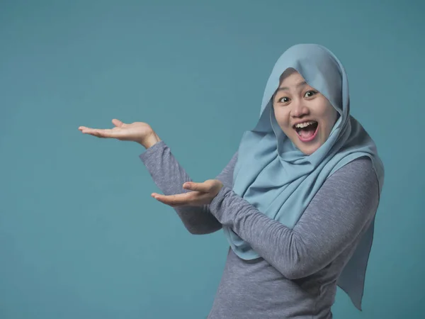Мусульманская леди представляет что-то на своей стороне с копировальным пространством — стоковое фото